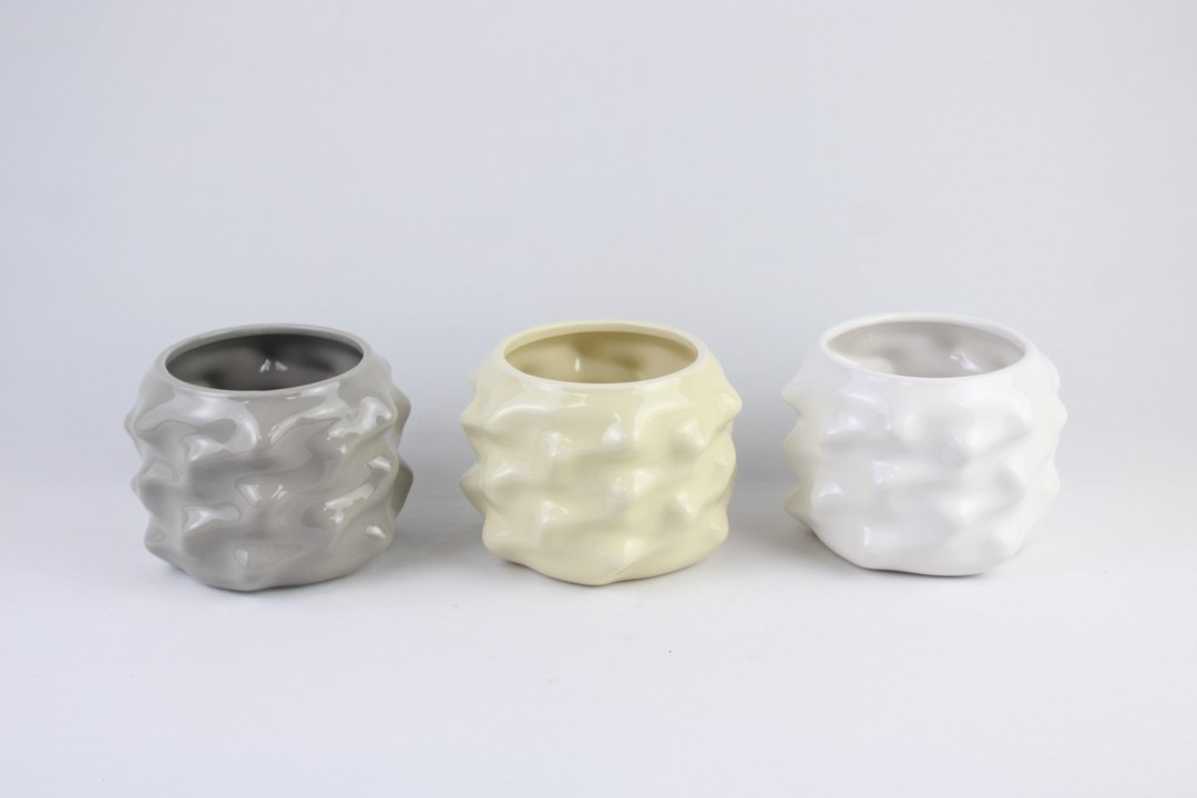 Three contemporary ceramic planters with organic sculptural textures and neutral glazed finishes.