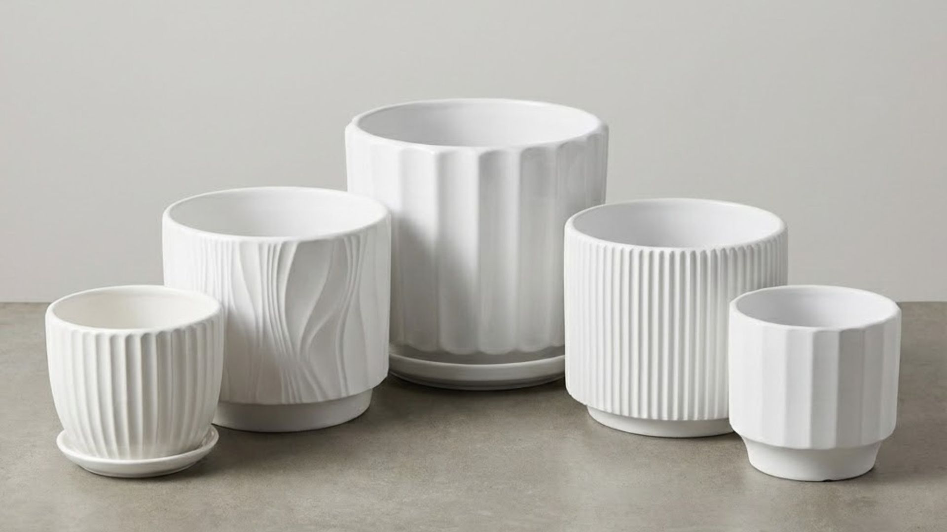 Glazed ceramic and natural terracotta planter samples showing surface finishes, drainage holes and matching saucers